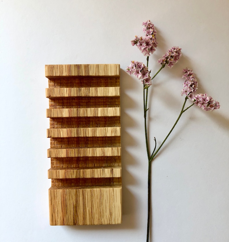 Puede incluir: Un jabonera de madera con cinco compartimentos, hecha de madera marr&oacute;n claro con un patr&oacute;n de veta natural. La jabonera est&aacute; sobre una superficie blanca.