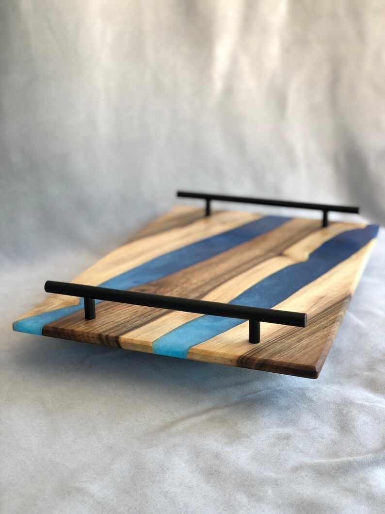 May include: A wooden serving tray with blue and light blue resin inlay and black metal handles.