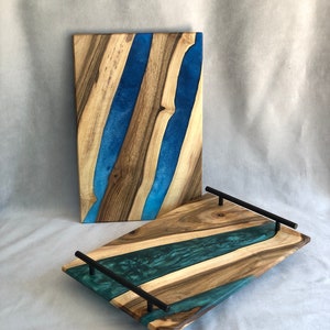May include: Two wooden serving trays with blue and green resin inlay. The larger tray has black metal handles.