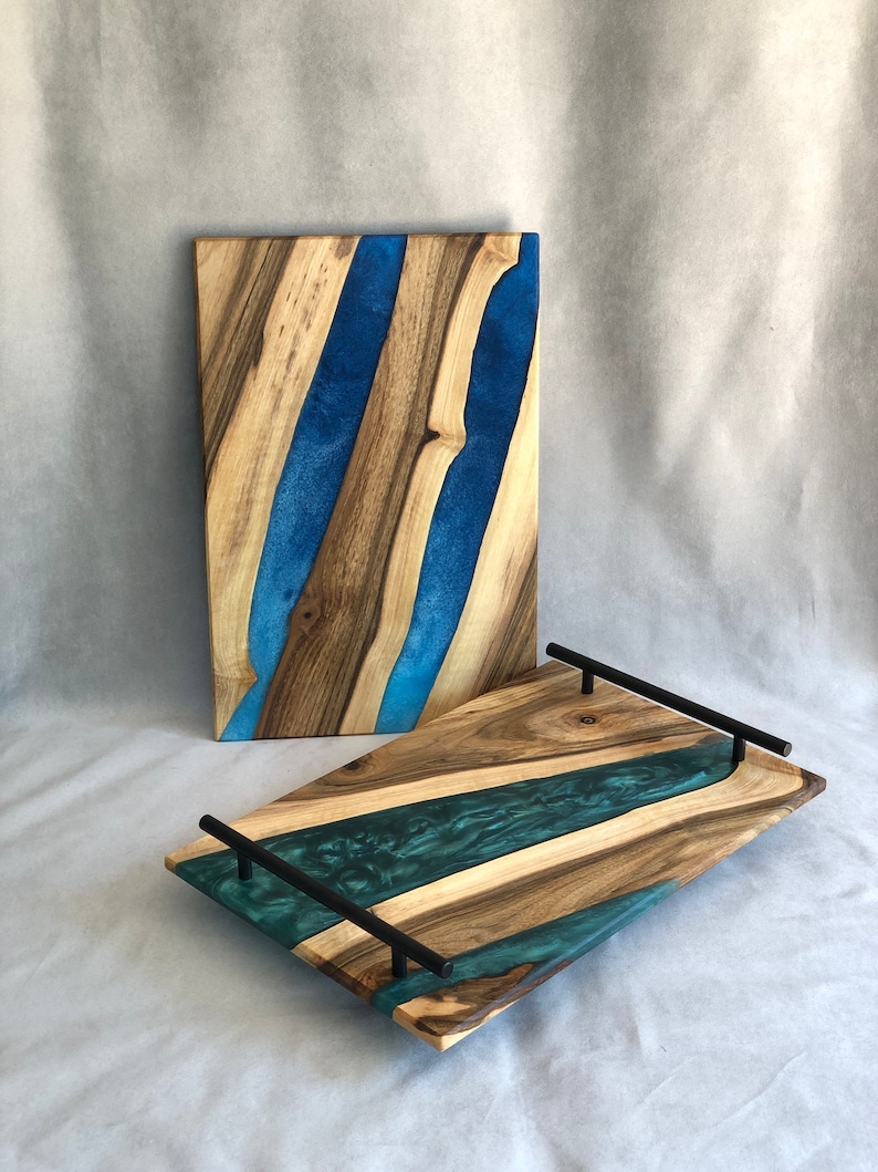 May include: Two wooden serving trays with blue and green resin inlay. The larger tray has black metal handles.
