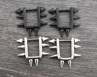 May include: Two pairs of hoop earrings with a spiked design. One pair is black and the other is silver.