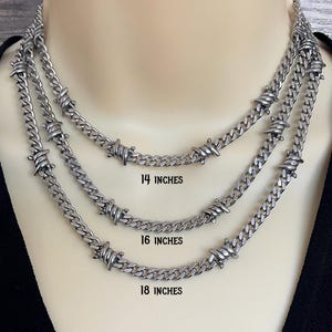 May include: Three silver necklaces with a barbed wire design. The necklaces are displayed at 35.5 cm, 40.6 cm, and 45.7 cm. The chains are made of a curb link style.