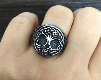 May include: A silver ring with a Celtic knot design featuring a tree of life motif.