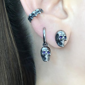 Zwarte schedel met paarse ogen oorbellen met schedelstekers, schedelsieraden, roestvrijstalen oorbellen, gotische sieraden, herenoorbellen