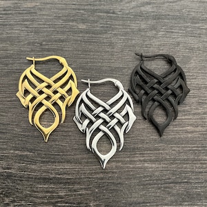 May include: Three pairs of dangle earrings with a Celtic knot design. The earrings are available in gold, silver, and black.
