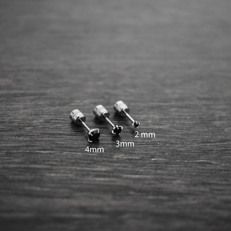 May include: Three silver stud earrings with black gemstones, lined up from largest to smallest. The earrings are labeled 4mm, 3mm, and 2mm.