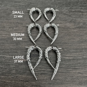 Peut inclure: Trois paires de boucles d'oreilles en argent de diff&eacute;rentes tailles&nbsp;: petite (23&nbsp;mm), moyenne (30&nbsp;mm) et grande (37&nbsp;mm). Les boucles d'oreilles ont la forme d'une pointe incurv&eacute;e avec une surface textur&eacute;e.