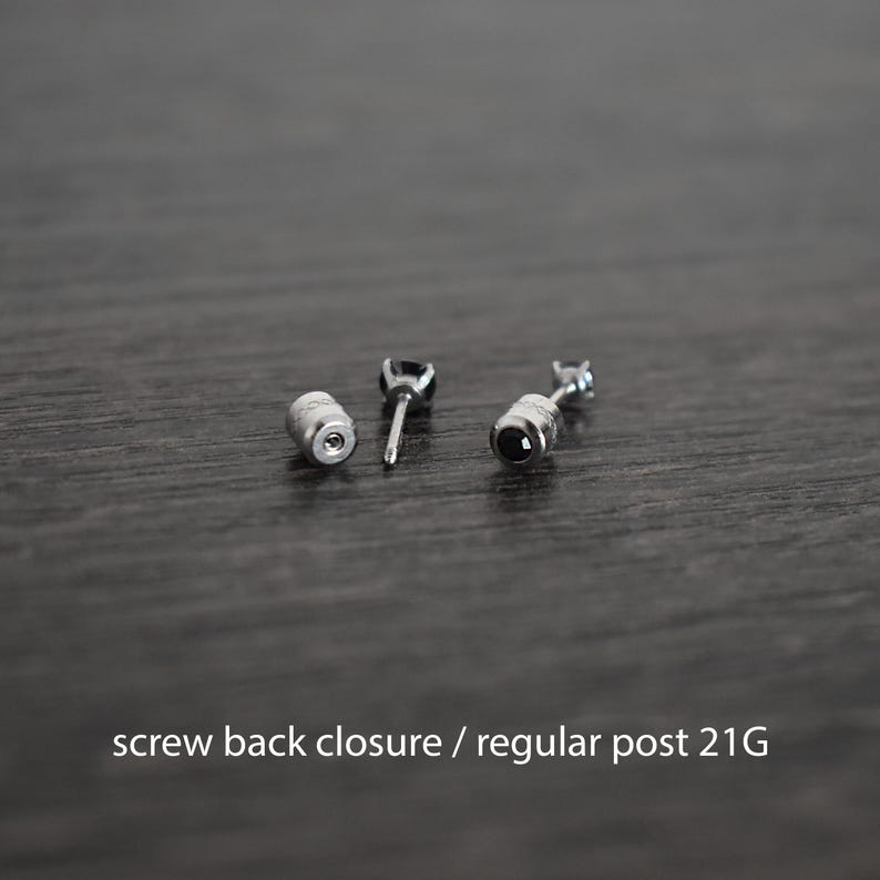 May include: A pair of black gemstone earrings with screw back closures. The earrings have a silver post and a 21 gauge thickness.