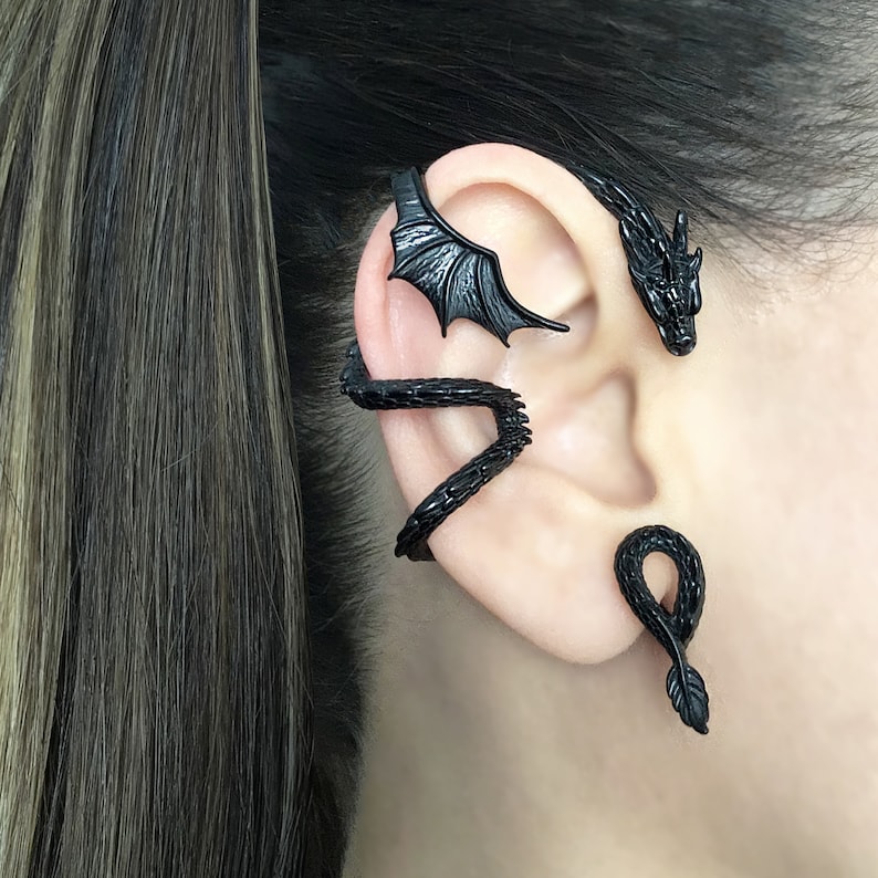 Puede incluir: Joyer&iacute;a de aro de oreja de drag&oacute;n negro. El aro se envuelve alrededor de la oreja y presenta una cabeza de drag&oacute;n y alas.