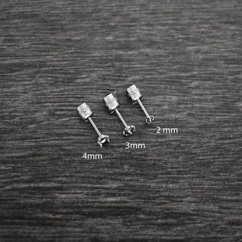 May include: Three silver stud earrings with a clear stone in the center. The earrings are 2 mm, 3 mm, and 4 mm in size.