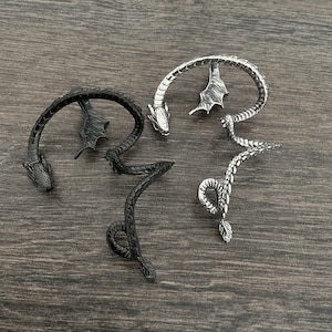 Puede incluir: Tres pendientes de drag&oacute;n de plata. Los pendientes tienen forma de drag&oacute;n con alas y cola. Los pendientes son un accesorio de moda popular.