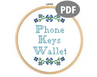 May include: A cross-stitch pattern for a hoop with a floral design and the text "Phone Keys Wallet".