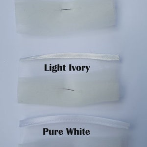 May include: Three swatches of white fabric with different shades of ivory. The top swatch is labeled "Ivory", the middle swatch is labeled "Light Ivory", and the bottom swatch is labeled "Pure White".
