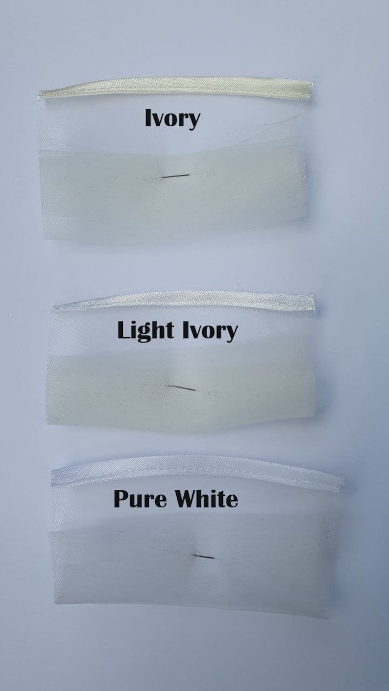 May include: Three swatches of white fabric with different shades of ivory. The top swatch is labeled "Ivory", the middle swatch is labeled "Light Ivory", and the bottom swatch is labeled "Pure White".