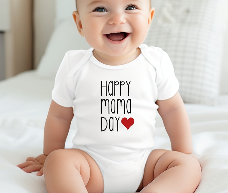 White onesie with the words happy mama day and a big red heart