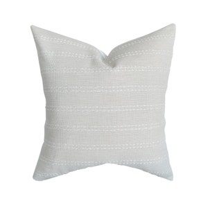 May include: A light gray throw pillow with white stitching in a horizontal stripe pattern.