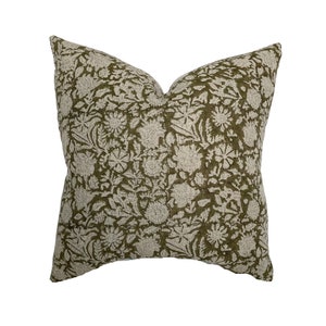 May include: A square throw pillow with a green background and a white floral pattern.