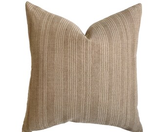 May include: A beige throw pillow with a subtle woven texture. The pillow is square shaped and has a simple design.