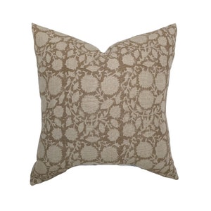 May include: A square throw pillow with a beige linen fabric and a brown floral pattern.