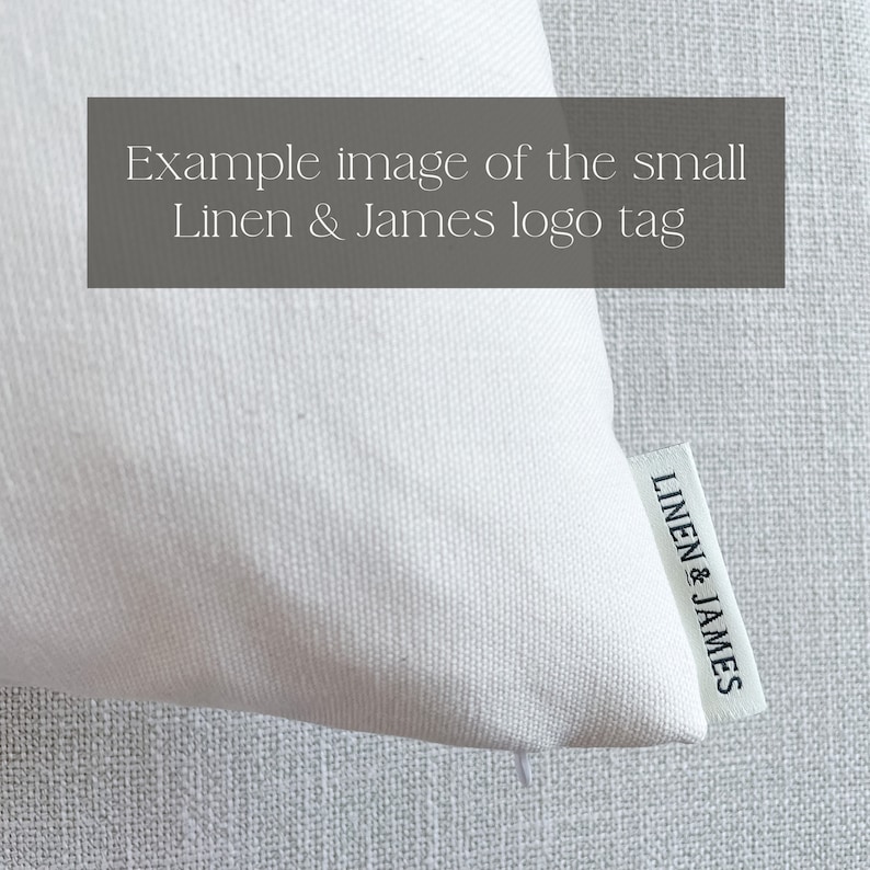 May include: White linen pillow with a small black and white woven label that reads "LINEN & JAMES"