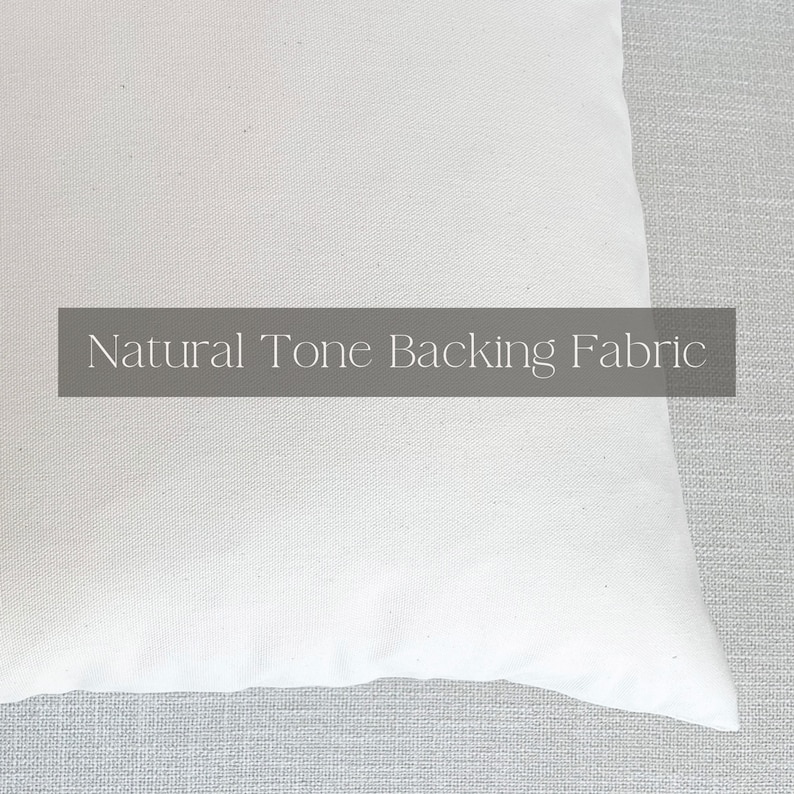May include: Close-up of a white cotton fabric with the text "Natural Tone Backing Fabric" printed on it.