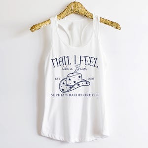 Puede incluir: Camiseta blanca de tirantes con un gr&aacute;fico azul que dice "Man, I feel like a Bride" con un sombrero de vaquero y estrellas. El texto tambi&eacute;n dice "Est. 2025" y "Sophia's Bachelorette."