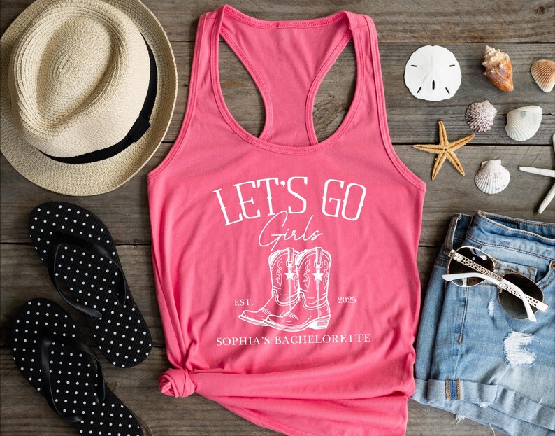 Puede incluir: Camiseta de tirantes rosa con el texto "Let's Go Girls" y un par de botas de vaquero. El texto "Est. 2025" y "Sophia's Bachelorette" tambi&eacute;n est&aacute;n impresos en la camiseta.
