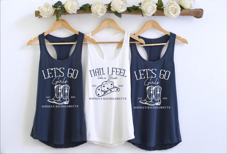 Puede incluir: Tres camisetas sin mangas con un tema de despedida de soltera. La camiseta blanca dice "Man, I feel like a bride" con un gr&aacute;fico de sombrero de vaquero. Las dos camisetas azul marino dicen "Let's go girls" con un gr&aacute;fico de un par de botas de vaquero. Las tres camisetas sin mangas tienen el texto "Sophia's Bachelorette" impreso en ellas.