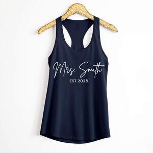 Pu&ograve; includere: Un top a canotta blu navy con il testo "Mrs. Smith EST 2025" in bianco.