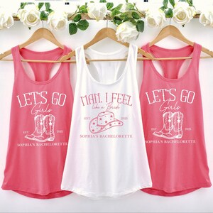 Puede incluir: Tres camisetas de tirantes rosas con texto y gr&aacute;ficos blancos. Las camisetas de tirantes dicen "Let's Go Girls", "Man I Feel Like a Bride" y "Let's Go Girls". Cada camiseta de tirantes tiene un gr&aacute;fico de un par de botas de vaquero y el texto "Sophia's Bachelorette".