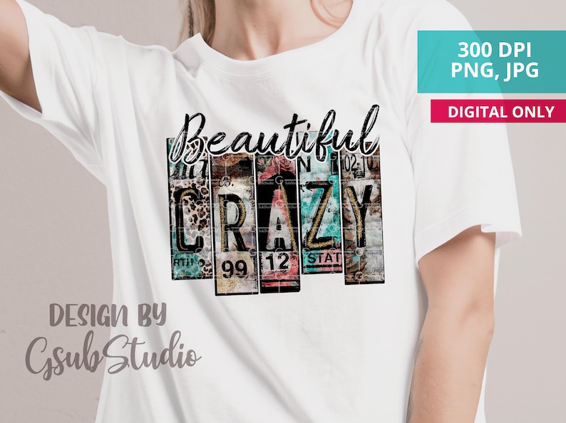 May include: A white t-shirt with a graphic design of the word "Beautiful" above the word "CRAZY" in a vintage license plate style. The design is in shades of blue, green, pink, and brown. The text "DESIGN BY Gsub Studio" is at the bottom of the shirt.
