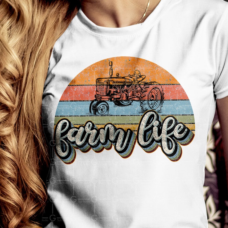 May include: White t-shirt with a vintage-style graphic of a red tractor driving through a sunset with the text "farm life" in a retro font.