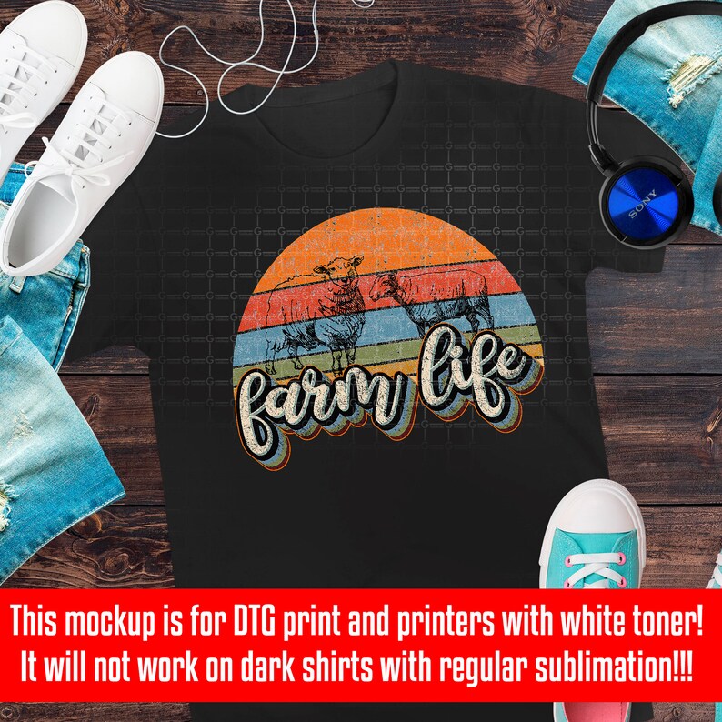 Puede incluir: Una camiseta negra con un gr&aacute;fico de estilo vintage de una puesta de sol con el texto "farm life" en una fuente retro colorida. El gr&aacute;fico presenta tres siluetas de ovejas.