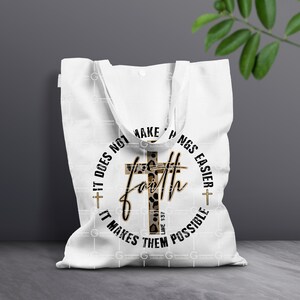 May include: White tote bag with a black circle design featuring a cross with a leopard print pattern and the text "Faith does not make things easier, it makes them possible" and the scripture reference "Luke 1:37".