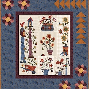 Peut inclure: Une courtepointe patchwork sur le thème du jardin. Le panneau central présente des motifs floraux, un nichoir et une brouette. La bordure est un motif floral bleu avec des motifs géométriques dans les coins. La courtepointe est un mélange de couleurs chaudes et froides.