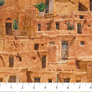 May include: A fabric with a repeating pattern of Southwestern adobe buildings in shades of tan, brown, and orange. The buildings have small windows and doors, with some featuring potted plants. A ruler is at the bottom, marked in inches.