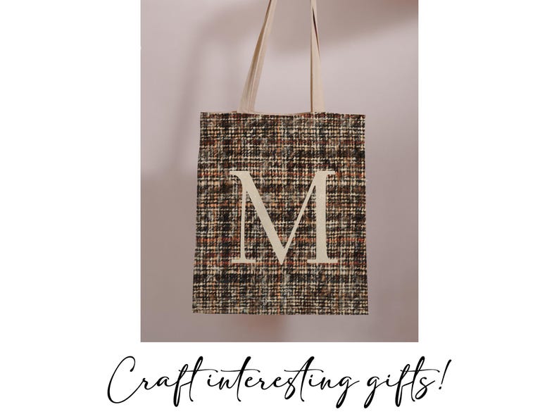 May include: A brown and black tote bag with a white letter "M" on the front. The bag has a woven texture.