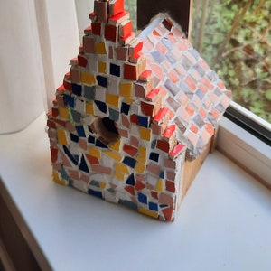 Cute birdhouse completely in the style of an Amsterdam canal house. The house is fully mosaic in various colours. Roof can be detached