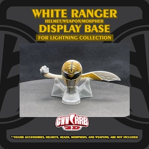 Puede incluir: Una base de exhibición gris para un casco, arma y morpher de White Ranger de la colección Lightning. La base sostiene un casco dorado y blanco con un arma a juego. El texto "WHITE RANGER DISPLAY BASE" es visible.