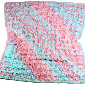 Könnte beinhalten: Eine gehäkelte Babydecke in den Farben Rosa, Türkis und Lila. Die Decke ist mit einem strukturierten Stich gearbeitet, der ein erhabenes Muster erzeugt.