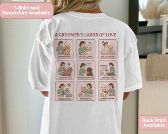 Könnte beinhalten: Weißes T-Shirt mit einer Grafik auf der Rückseite, die einen Hundefriseur und Hunde zeigt. Der Text "A Groomer's Labor of Love" steht über den Illustrationen. Auf dem Shirt steht "T-Shirt und Sweatshirt erhältlich" und "Rückendruck verfügbar."