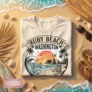Puede incluir: Sudadera crema con un gráfico de Ruby Beach, Washington, con palmeras, olas y una puesta de sol. El texto "Ruby Beach Washington" se muestra encima de la escena de la playa. También se ven las palabras "Front and Back Print Available".