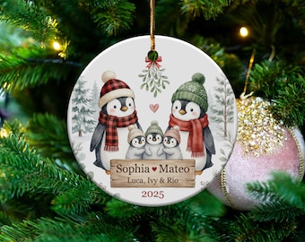 May include: Round Christmas ornament featuring a family of penguins wearing hats and scarves. The ornament has the names "Sophia ❤ Mateo, Luca, Ivy & Rio" and the year "2025" printed on it. The ornament is hanging on a Christmas tree.