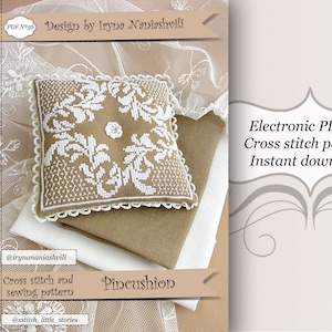 以下が含まれることがあります： ピンcushionのためのクロスステッチパターン。パターンは、茶色の背景に白い花のデザインが特徴です。パターンは、すぐにダウンロードできます。