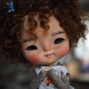 a close up of a doll with curly hair