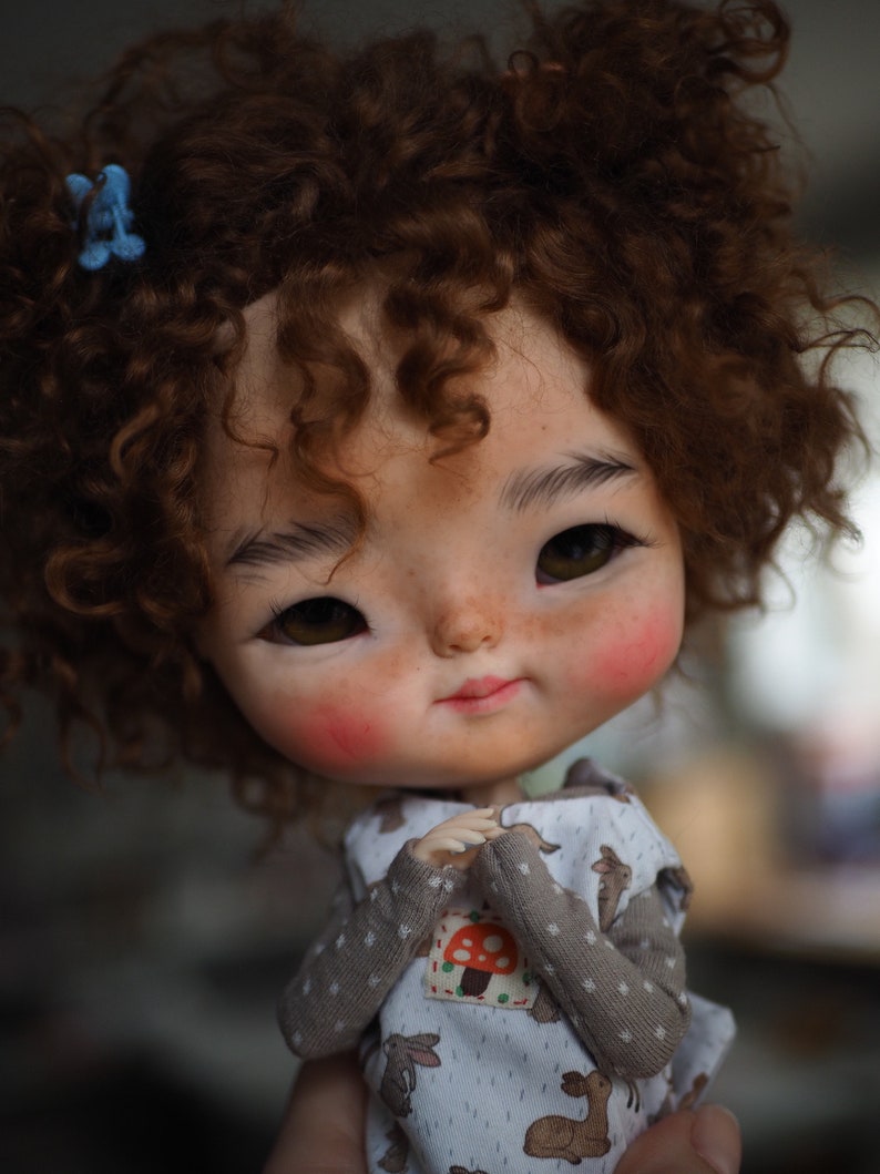 a close up of a doll with curly hair