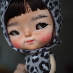 a close up of a doll wearing a cat costume