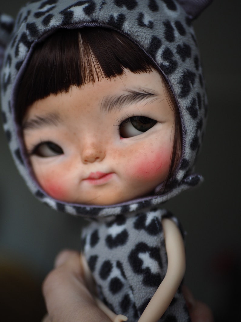 a close up of a doll wearing a cat costume