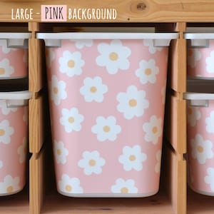 May include: Pink storage bins with white daisy patterns and yellow centers. The bins are arranged in a wooden shelf unit. The text "LARGE - PINK BACKGROUND" is at the top of the image.