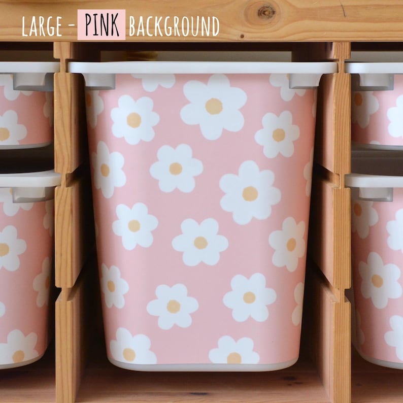 May include: Pink storage bins with white daisy patterns and yellow centers. The bins are arranged in a wooden shelf unit. The text "LARGE - PINK BACKGROUND" is at the top of the image.